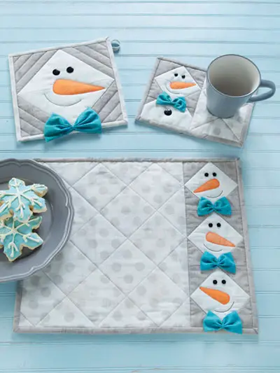 Snowman table setting sewing pattern featuring a pot holder, mug rug, and place mat